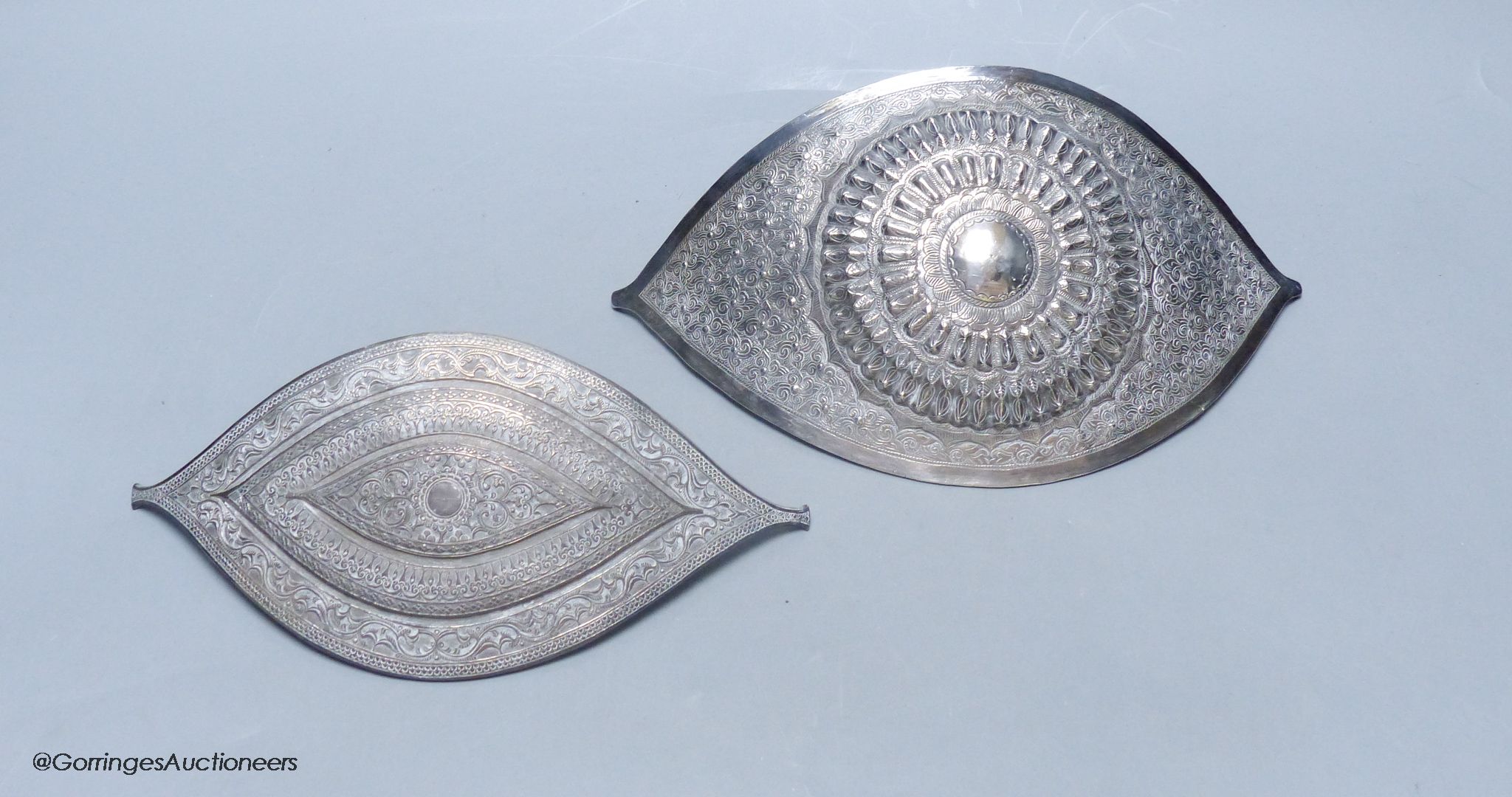 A Chinese Straits large white metal belt buckle, of curved navette form and a similar smaller buckle, L 24.5cm & 20.5cm